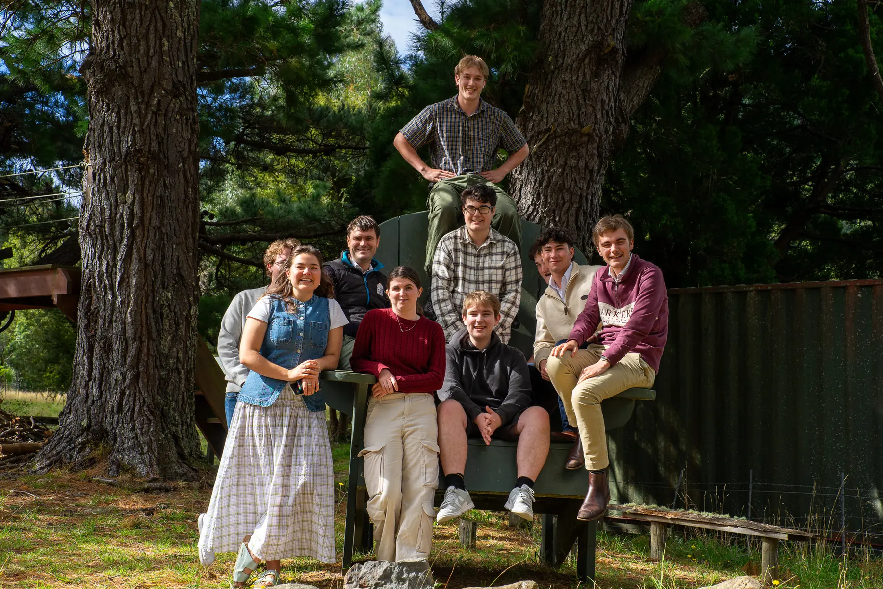 Outdoor group portrait gathered in front of a large chair